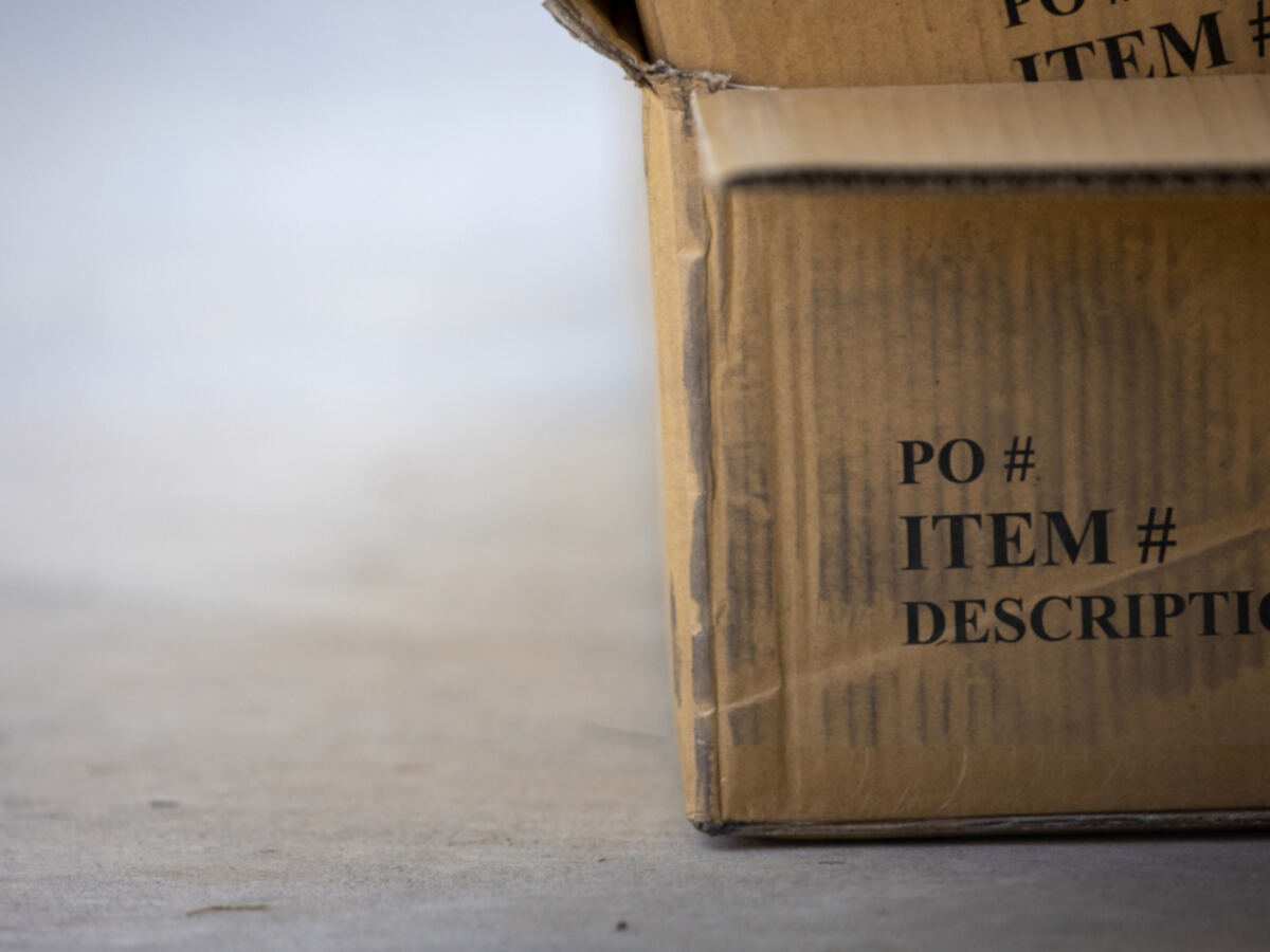A cardboard shipping box printed with PO and item fields, ready for order fulfillment
