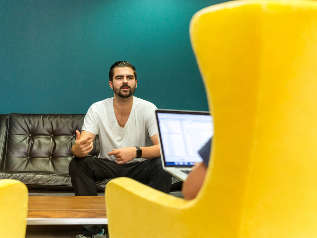 A person seated in a lounge chair having a relaxed interview conversation